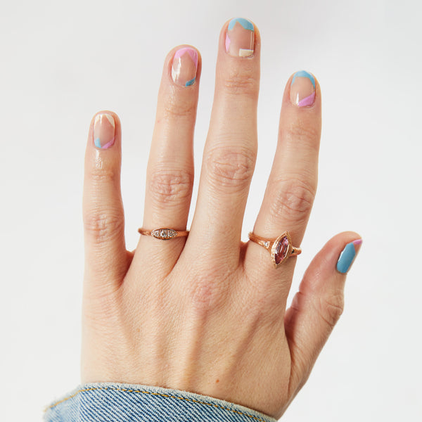 Dainty Diamond Trio Ring on the ring finger and a marquise Baby Pink Spinel ring on the index finger. Both in rose gold and made in Oakland.