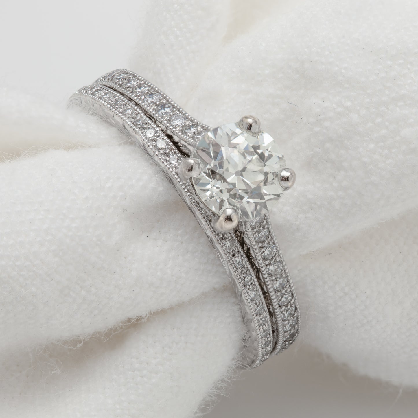 Close-up of 18k white gold ring with an old cut diamond and diamonds. Included is a matching eternity band.