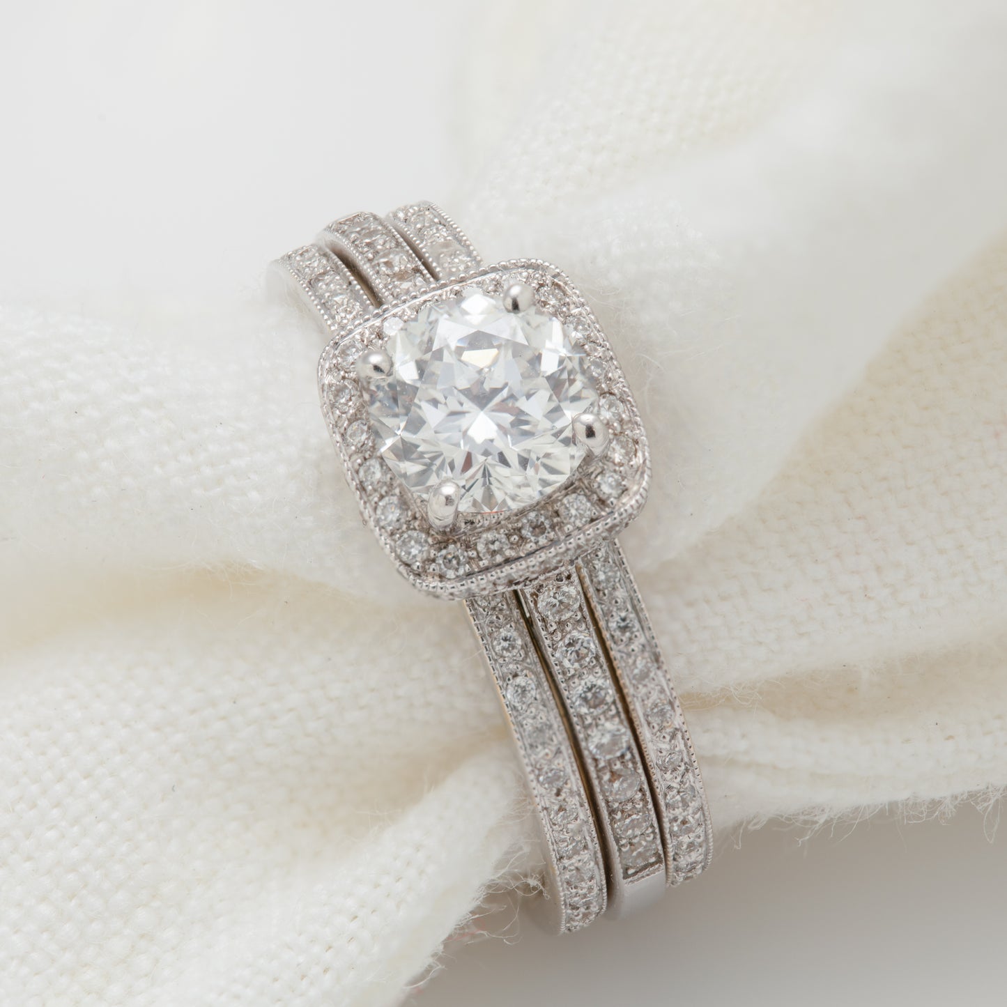 Close-up of an 18k white gold ring set with diamonds, and two eternity bands included.