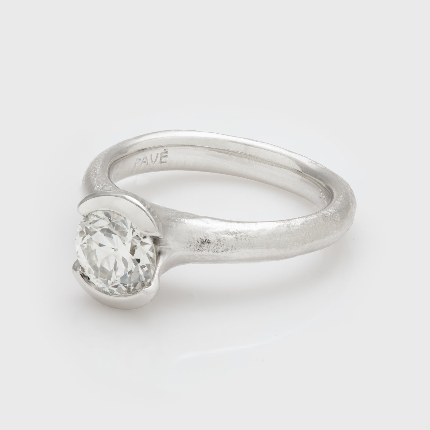 Side view of a platinum ring with diamond accents and an old cut diamond gem.
