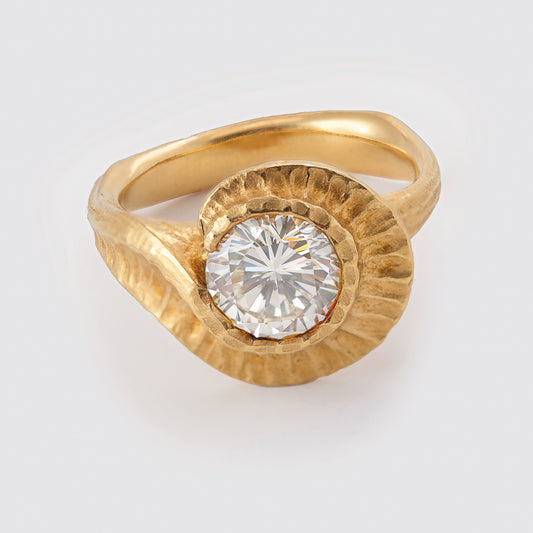 Yellow metal ring with round gem
