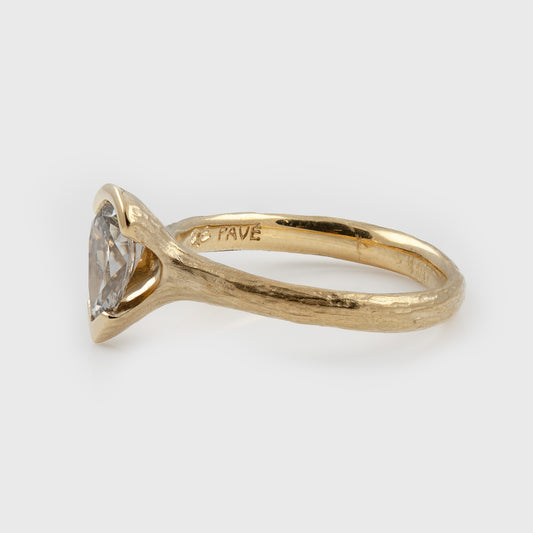 Side view of yellow gold ring featuring a pear diamond center stone with a textured band, photographed on a white background.