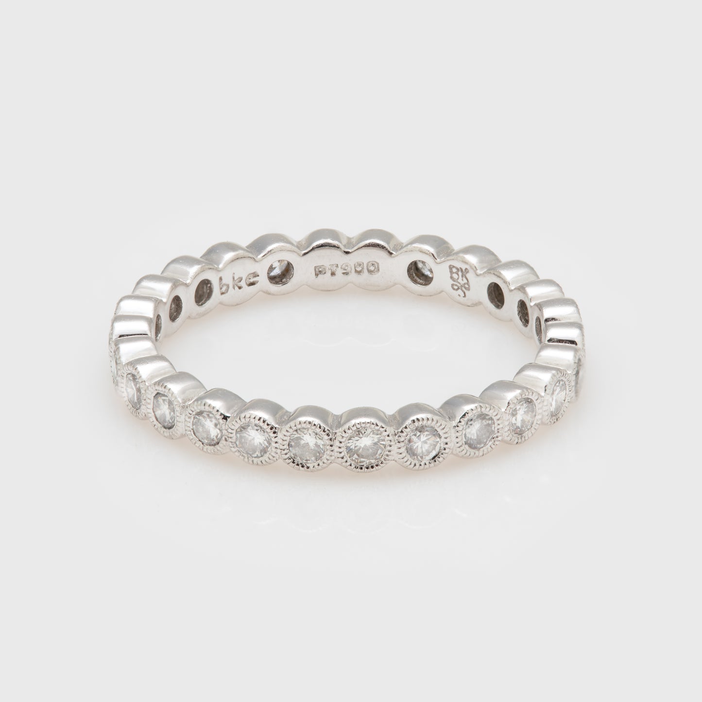 Close-up of a platinum band featuring diamonds with milgrain accents.