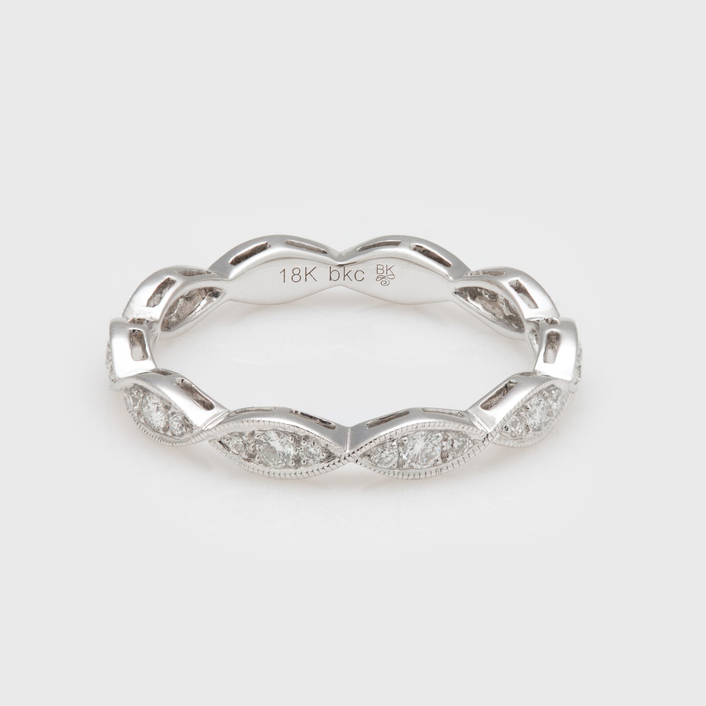 Close-up of an 18k white gold band with diamonds.