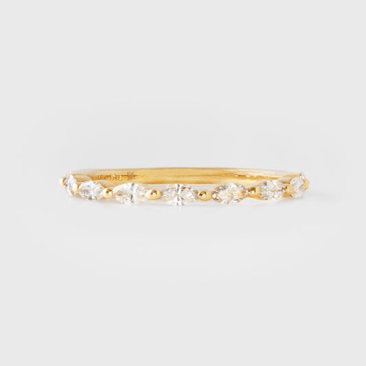 Gold ring with diamonds on a light gray background