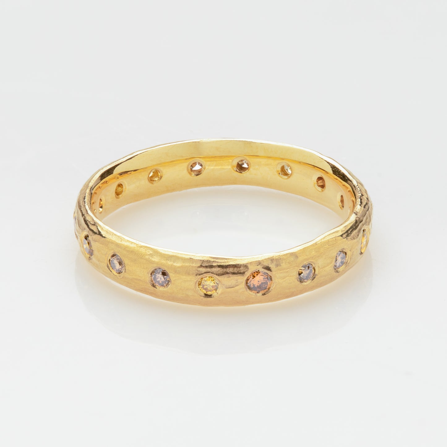 Close-up of an 18k royal yellow gold band with multicolor diamonds.