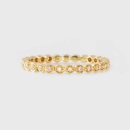 Gold ring with diamonds on a light gray background