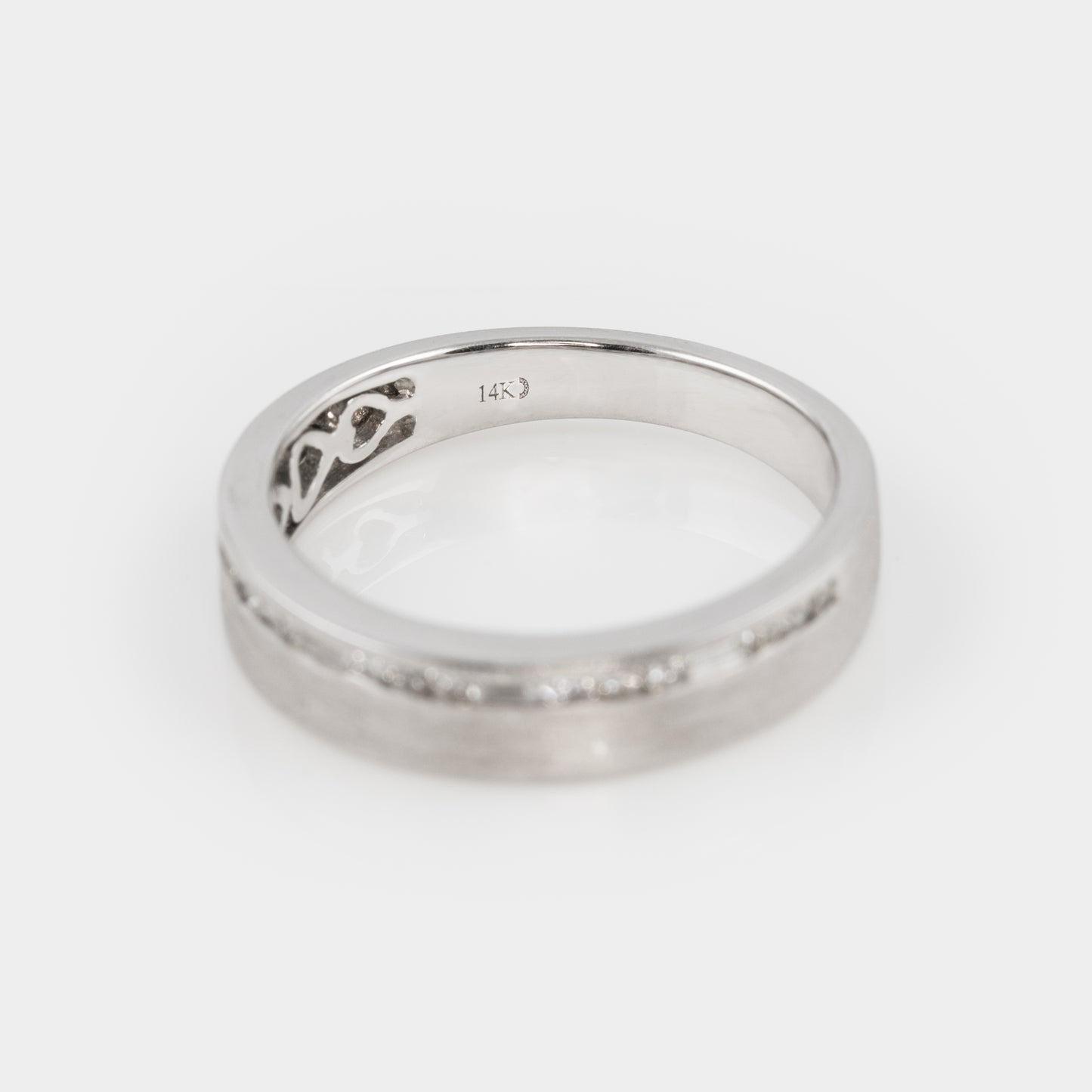Silver ring with a subtle design on a white background