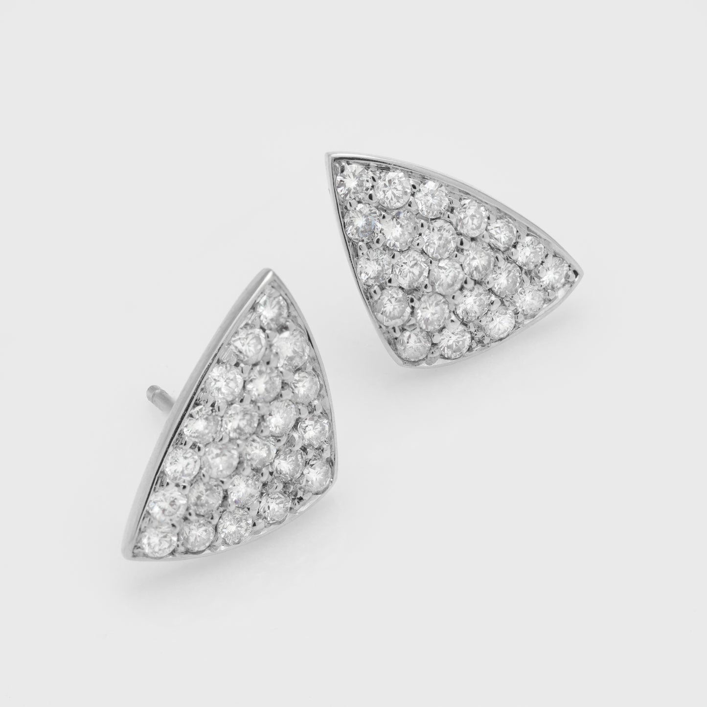 Close-up of handmade platinum earrings with round brilliant cut diamonds.