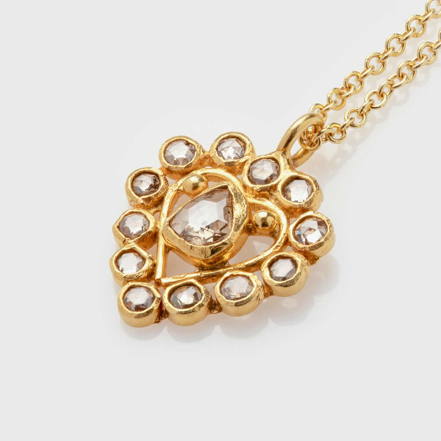 Close-up of an 18 karat yellow gold necklace with organic shaped rose cut diamonds.