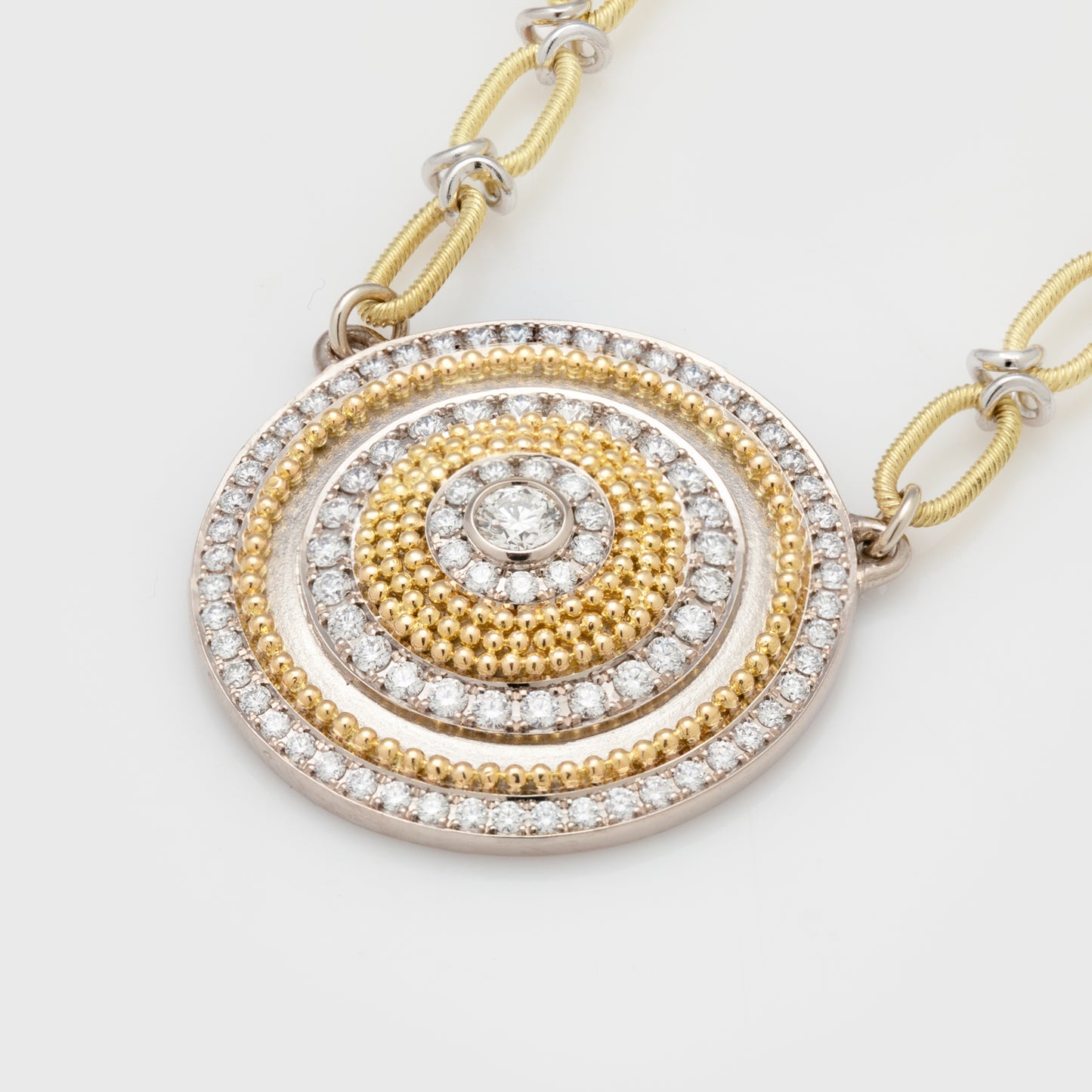 Close-up of an 18k white gold and 20k yellow gold necklace with diamonds and a handmade 18k two-tone flower chain.