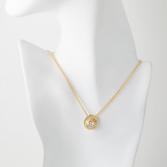 Gold necklace with a pendant on a mannequin bust against a white background