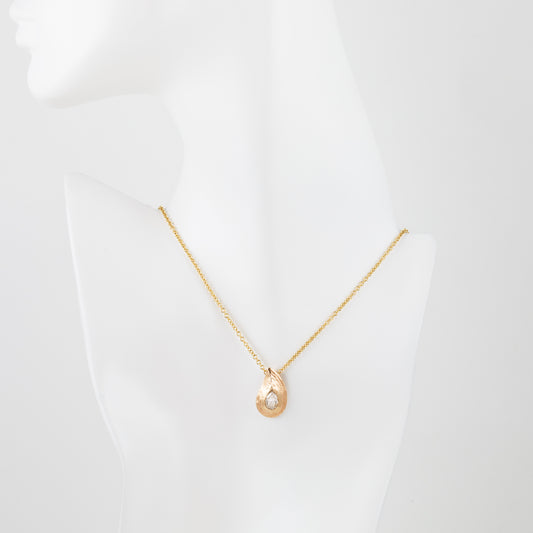 Pear shaped gold pendant with redwood bark texture on white mannequin