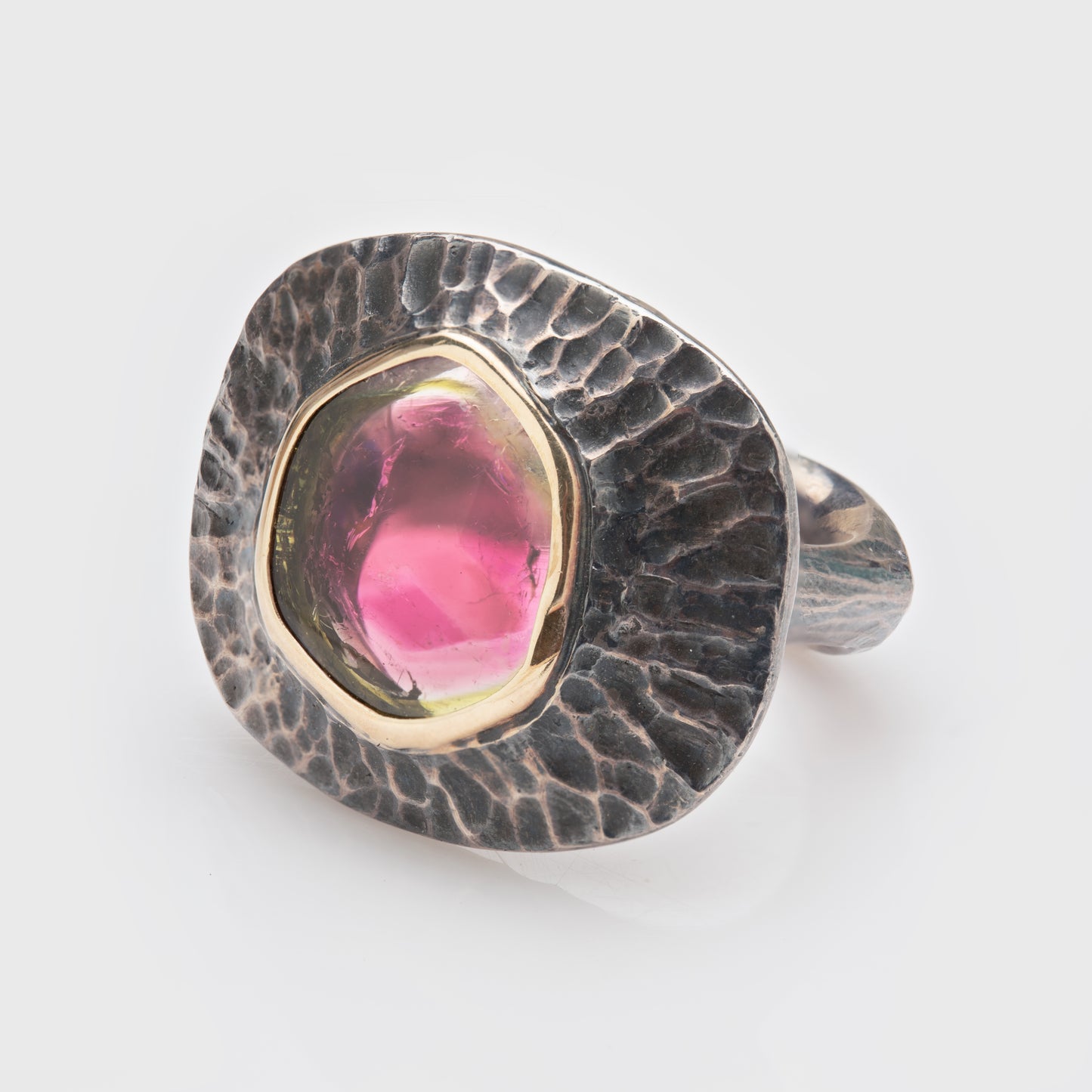 Close-up of a sterling silver ring with tourmaline and 22k yellow gold accents.