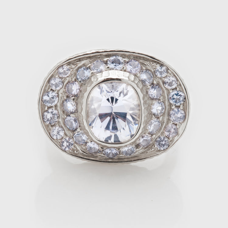 Close-up of a platinum ring with a light lavender sapphire and lavender spinel accents.