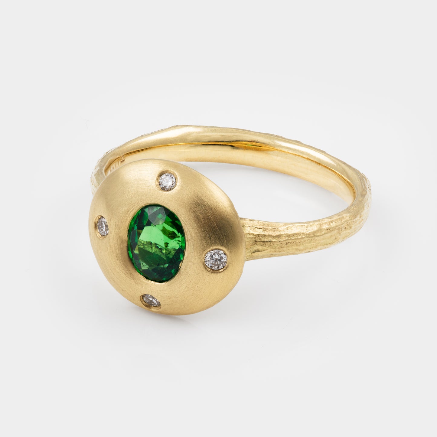 Gold ring with a green gemstone and small diamonds on a white background