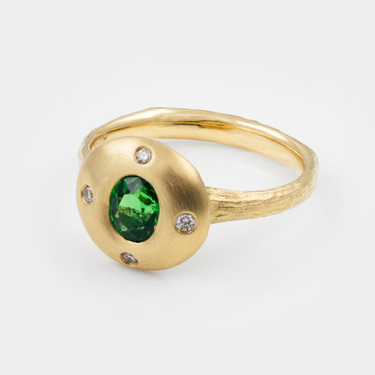 Gold ring with a green gemstone and small diamonds on a white background