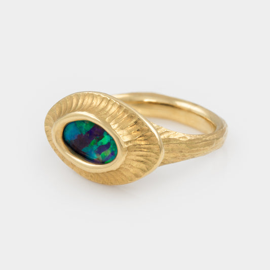 Gold ring with an opal stone on a white background