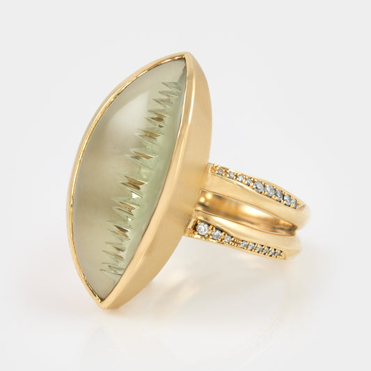 Gold ring with a pale green gemstone and small diamonds.