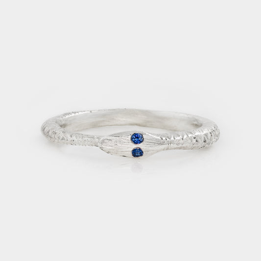 Silver ring with a blue gemstone on a white background