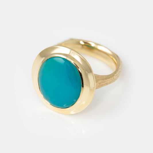 Gold ring with a blue stone on a white background