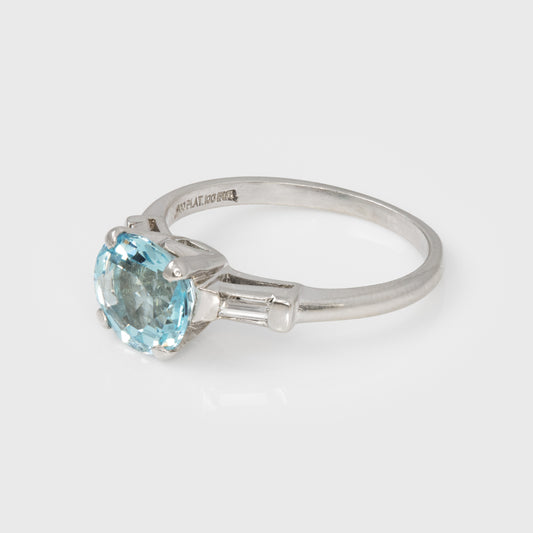 Platinum ring with a blue gemstone on a white background