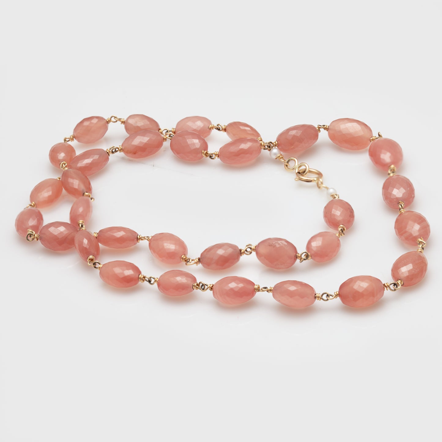 A 14k yellow gold necklace with rhodocrosite gemstones.
