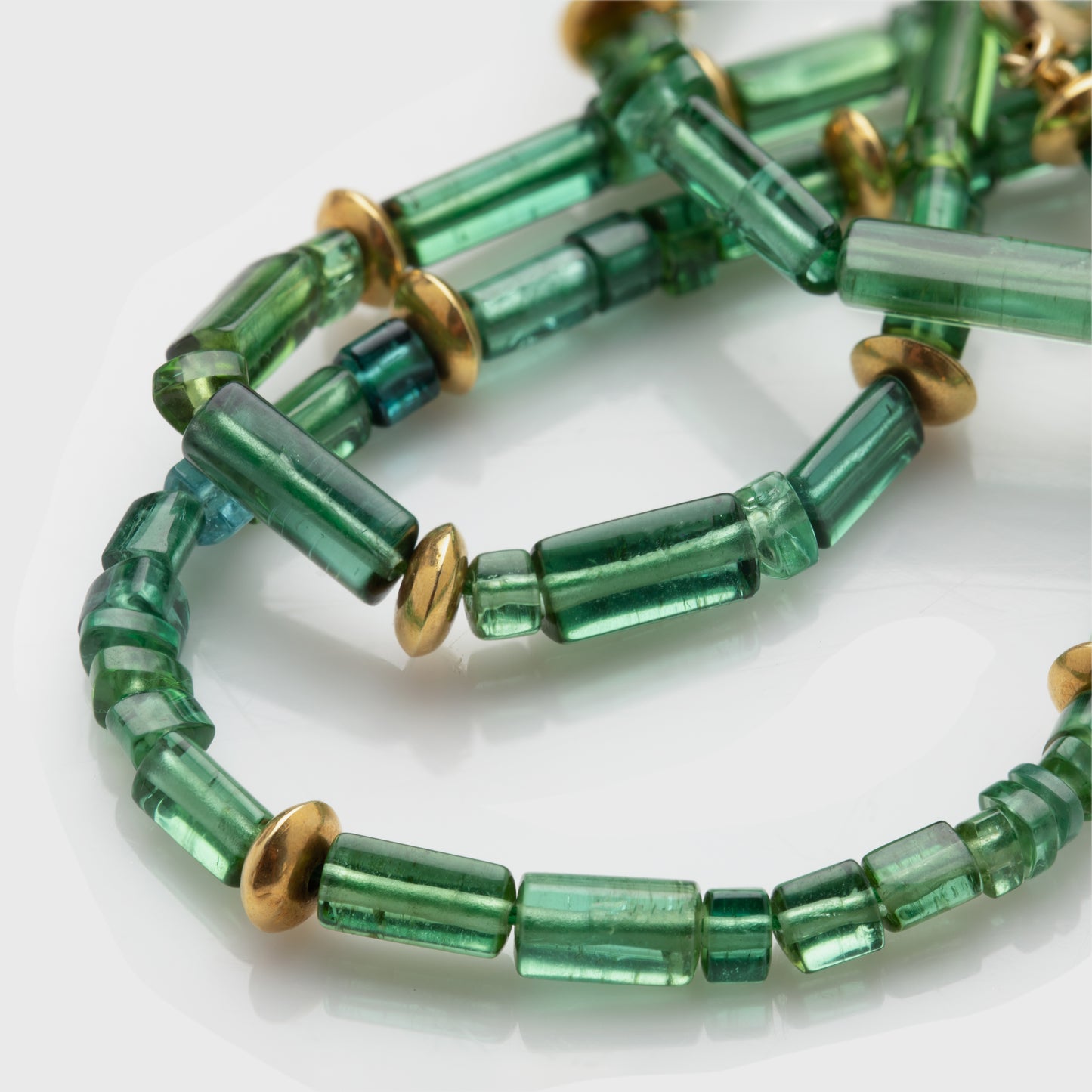 Close-up of a Brazil tourmaline necklace with 22k yellow gold beads and a 14k yellow gold clasp.