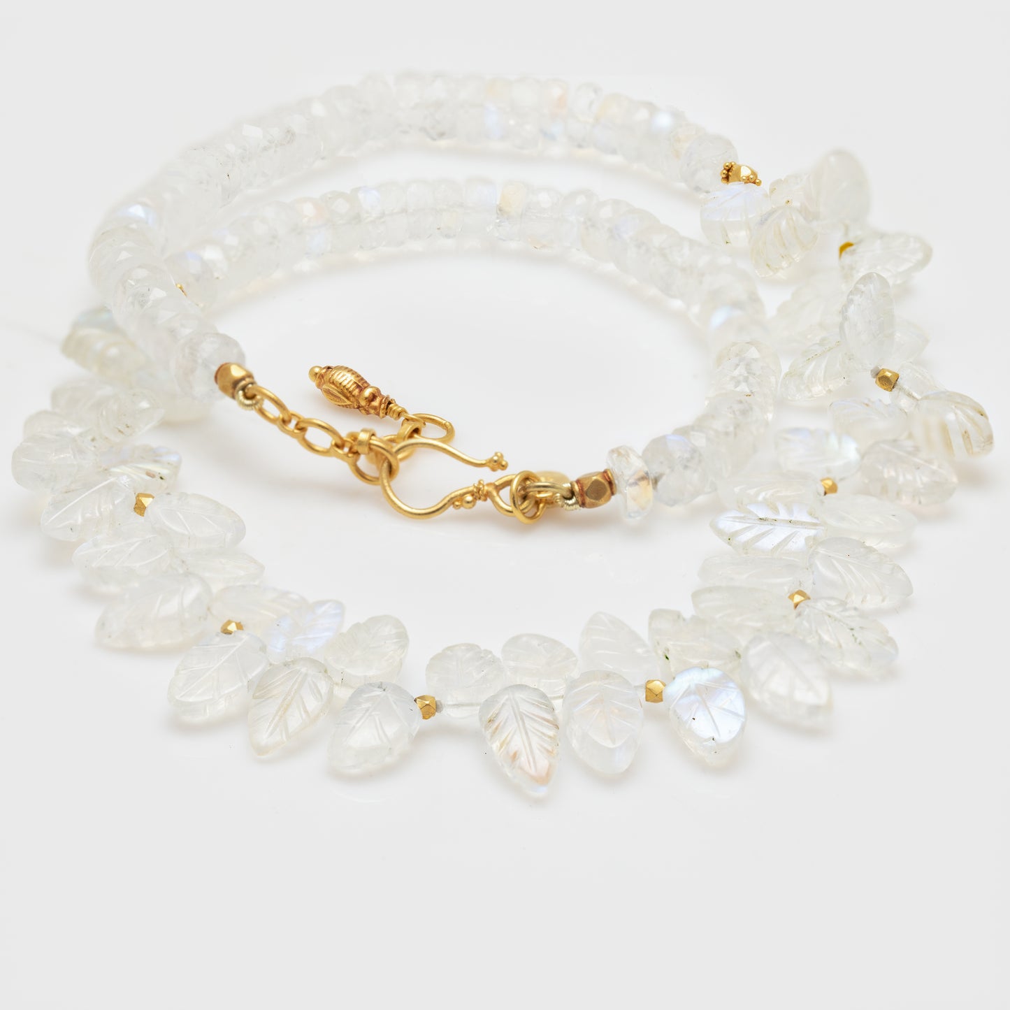 Close-up of an 18k yellow gold necklace with rainbow moonstone and 18k yellow gold spacer beads.