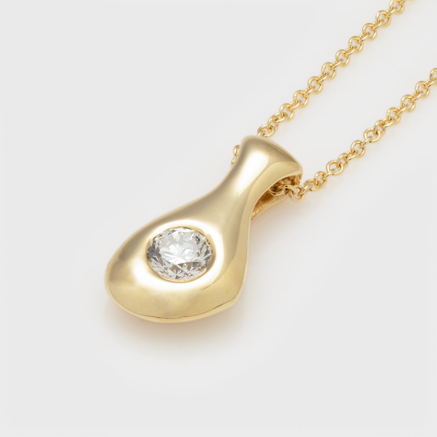 Close-up of an 18k yellow royal gold necklace with diamond.