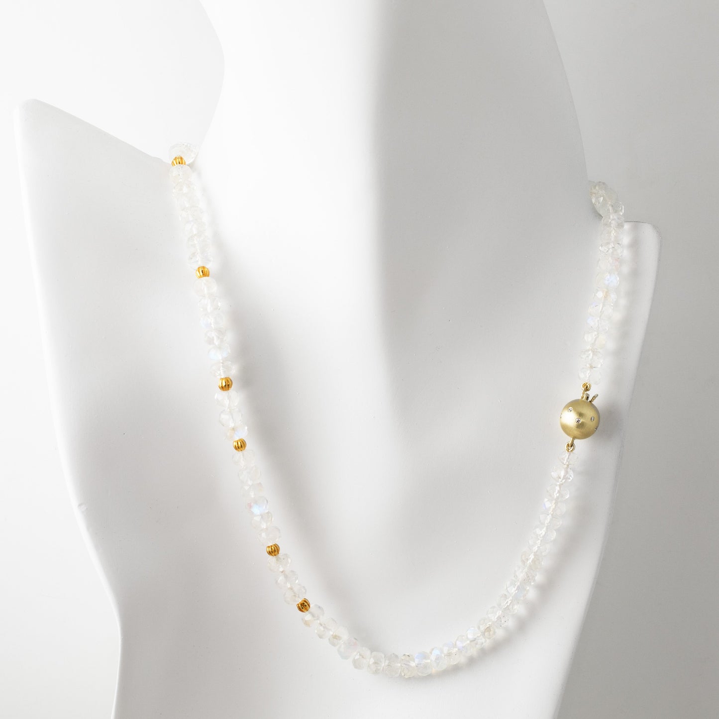 Moonstone necklace with gold accents on a mannequin against a white background