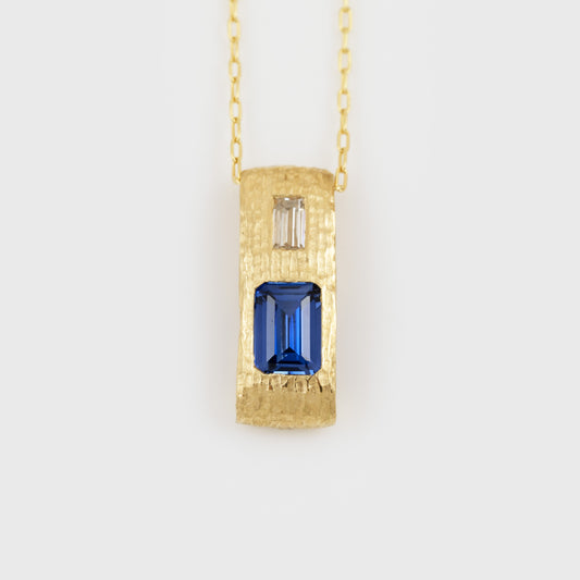 Yellow gold pendant feauturing emerald cut blue Sapphire and baguette cut Diamond