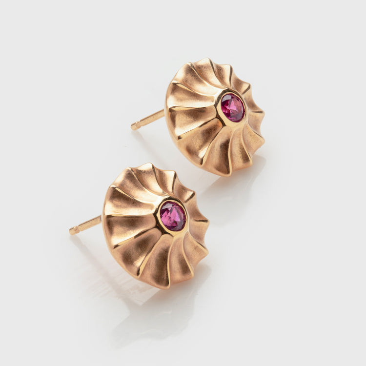 Close-up of 18k rose gold studs with pink sapphires.