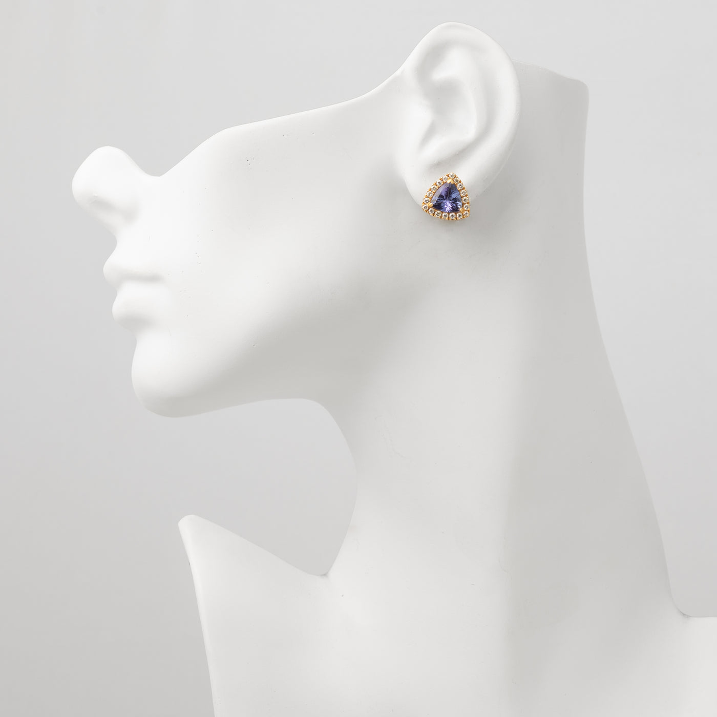 Angled view of a tanzanite halo stud earring.