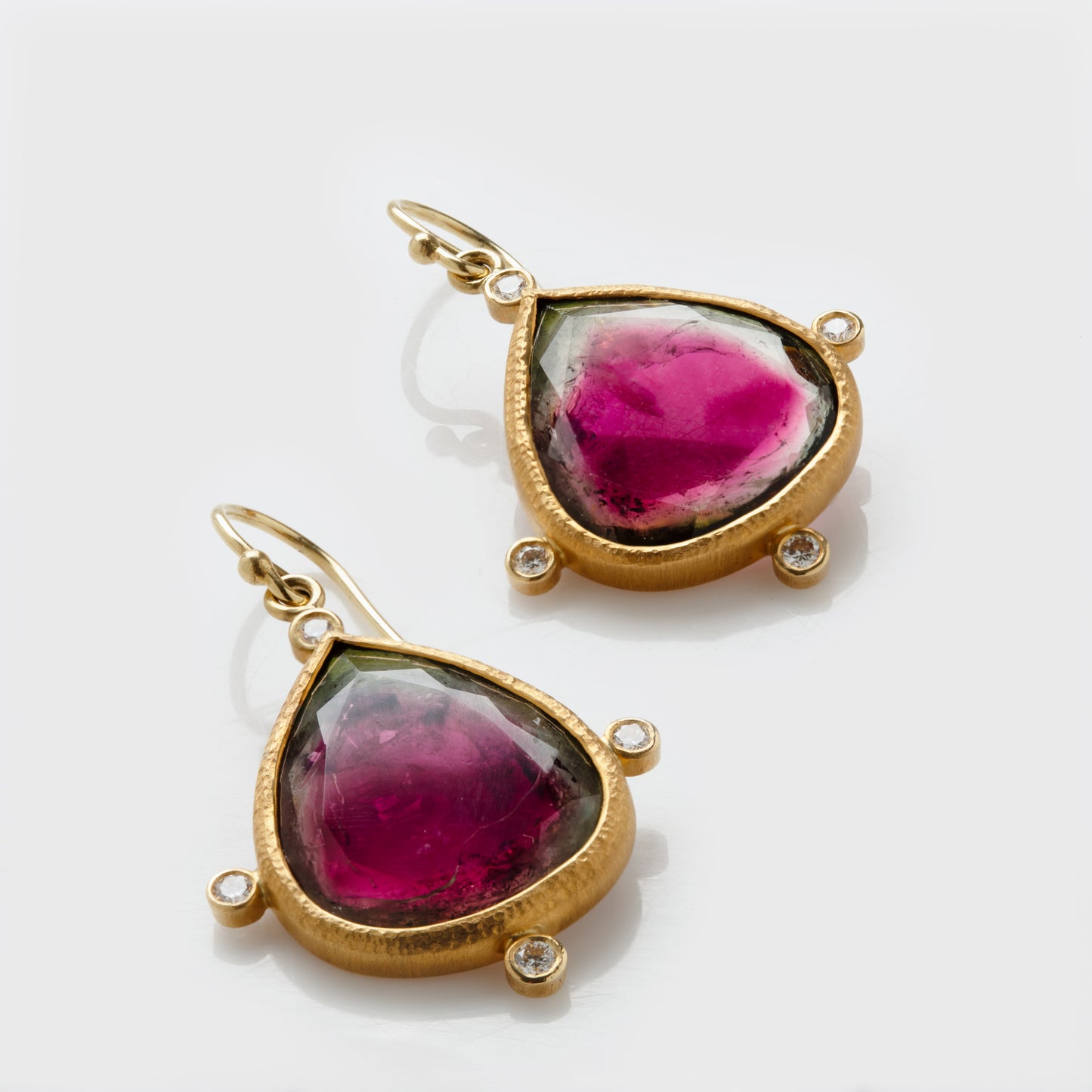 Close-up of 18 karat yellow gold earrings with bicolor tourmaline and diamond accents.