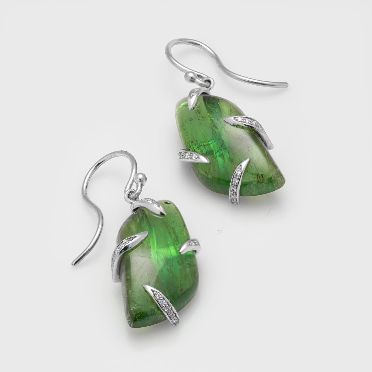 Close-up of platinum earrings with tourmaline and diamonds.