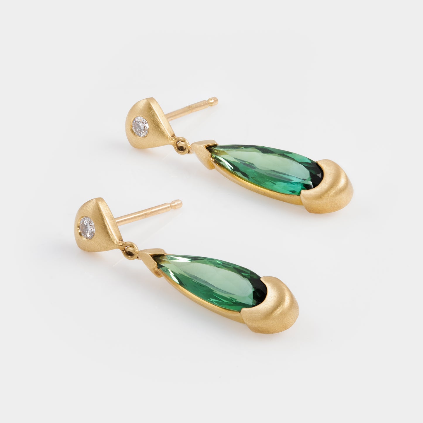 18k matte yellow gold earrings with green tourmaline gemstones on a white background
