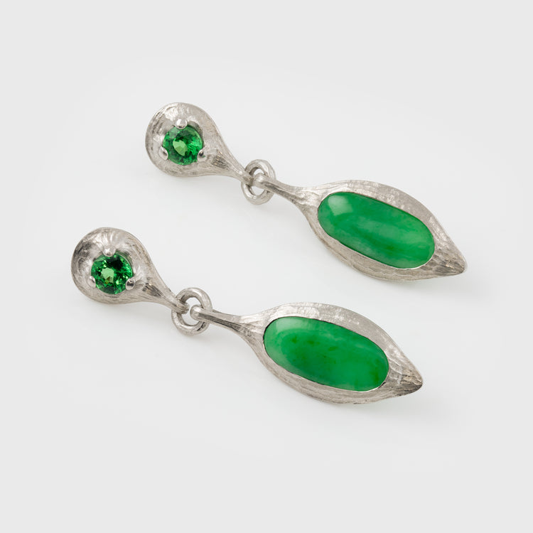 Pair of silver earrings with green stones on a white background