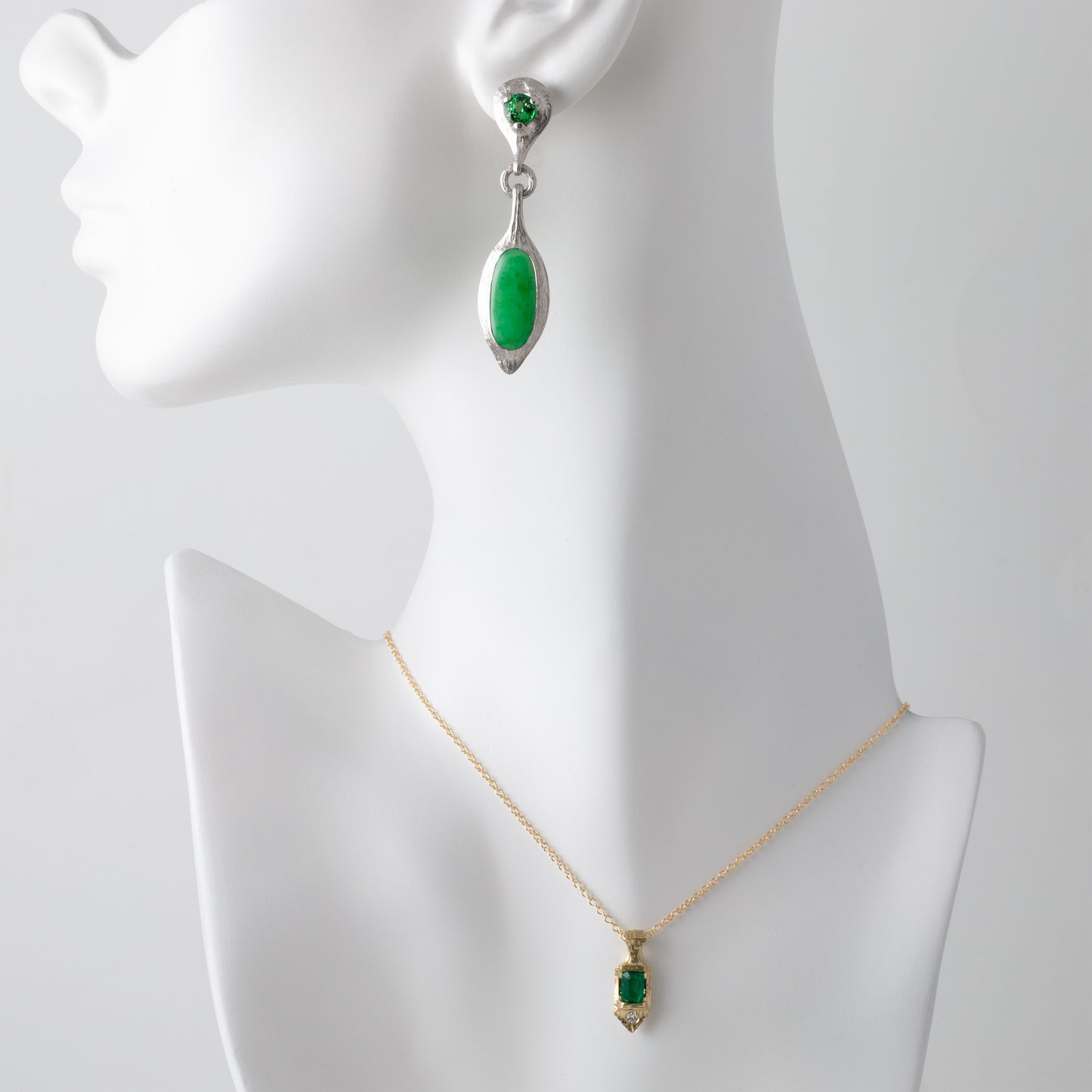 Green gemstone necklace and earring set on a mannequin with a white background