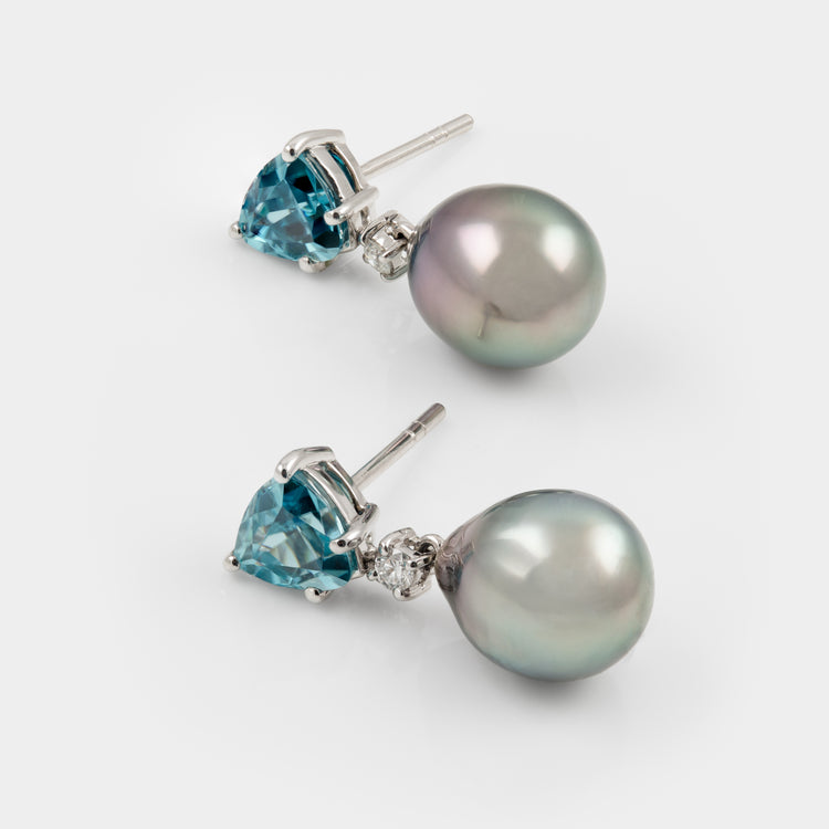 Pair of earrings with blue Zircons and pearls on a white background