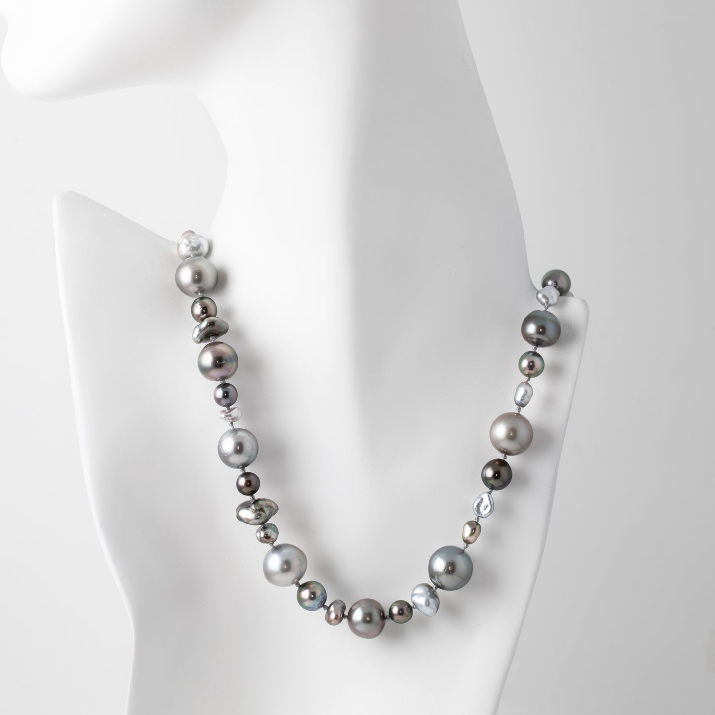 Necklace with gray pearls on a mannequin bust against a white background