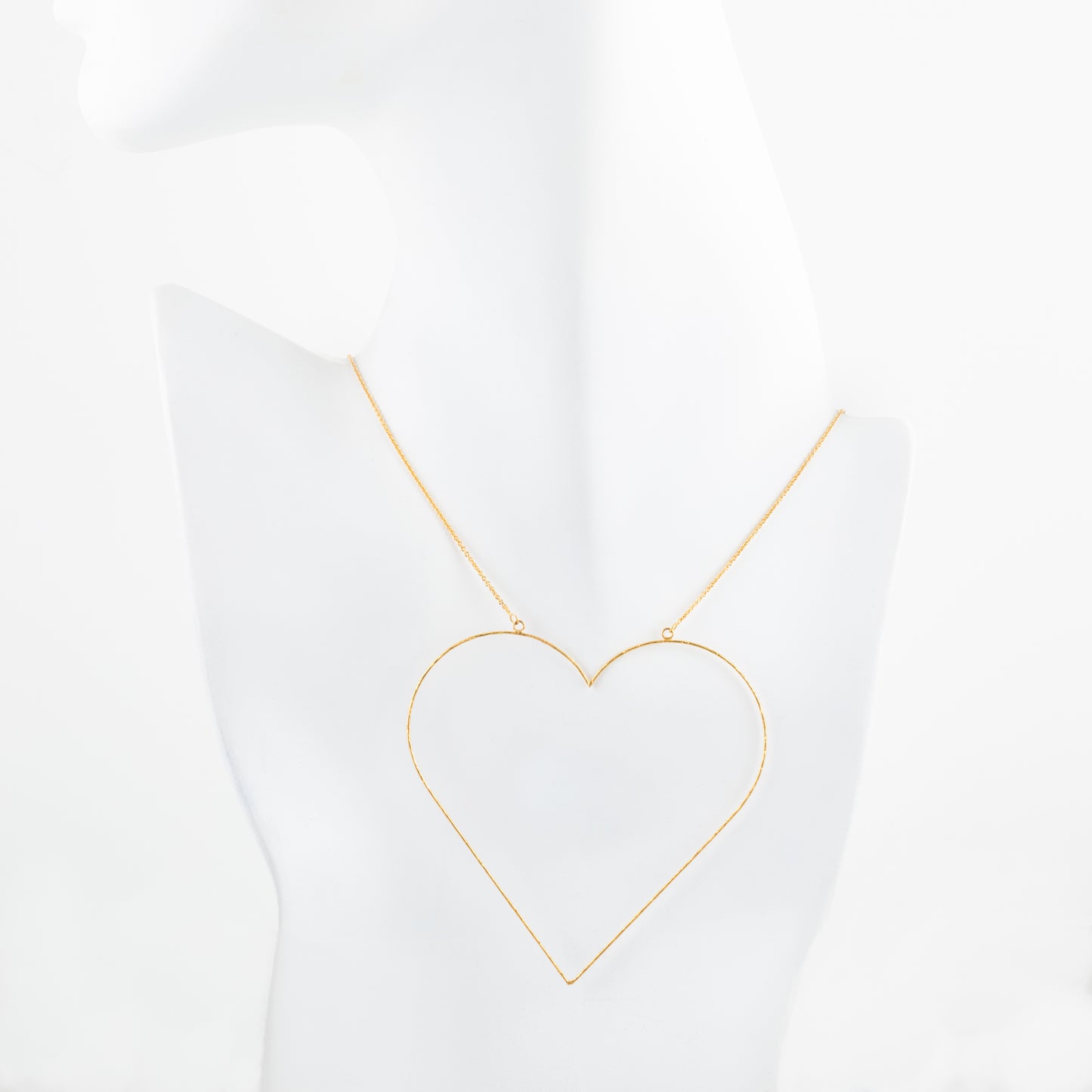 Gold heart-shaped necklace on a white background