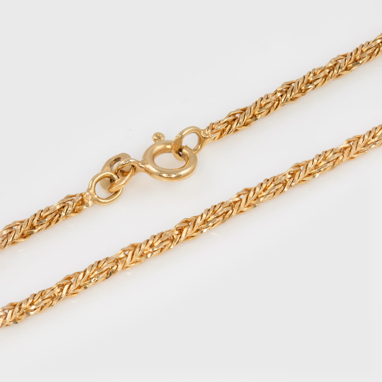 Close-up of an 18k yellow gold wheat chain.