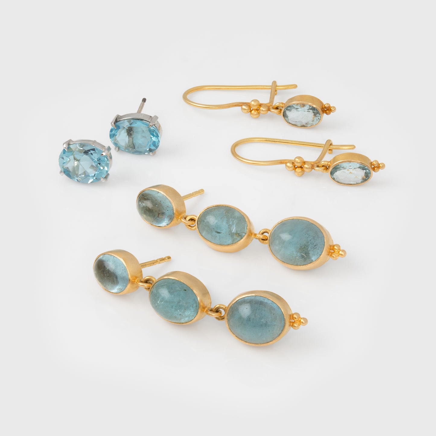 Three pairs of blue gemstone earrings on a white background