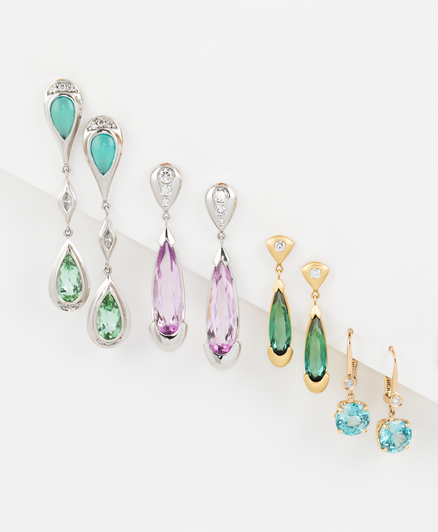 Collection of colorful teardrop-shaped earrings on a white background