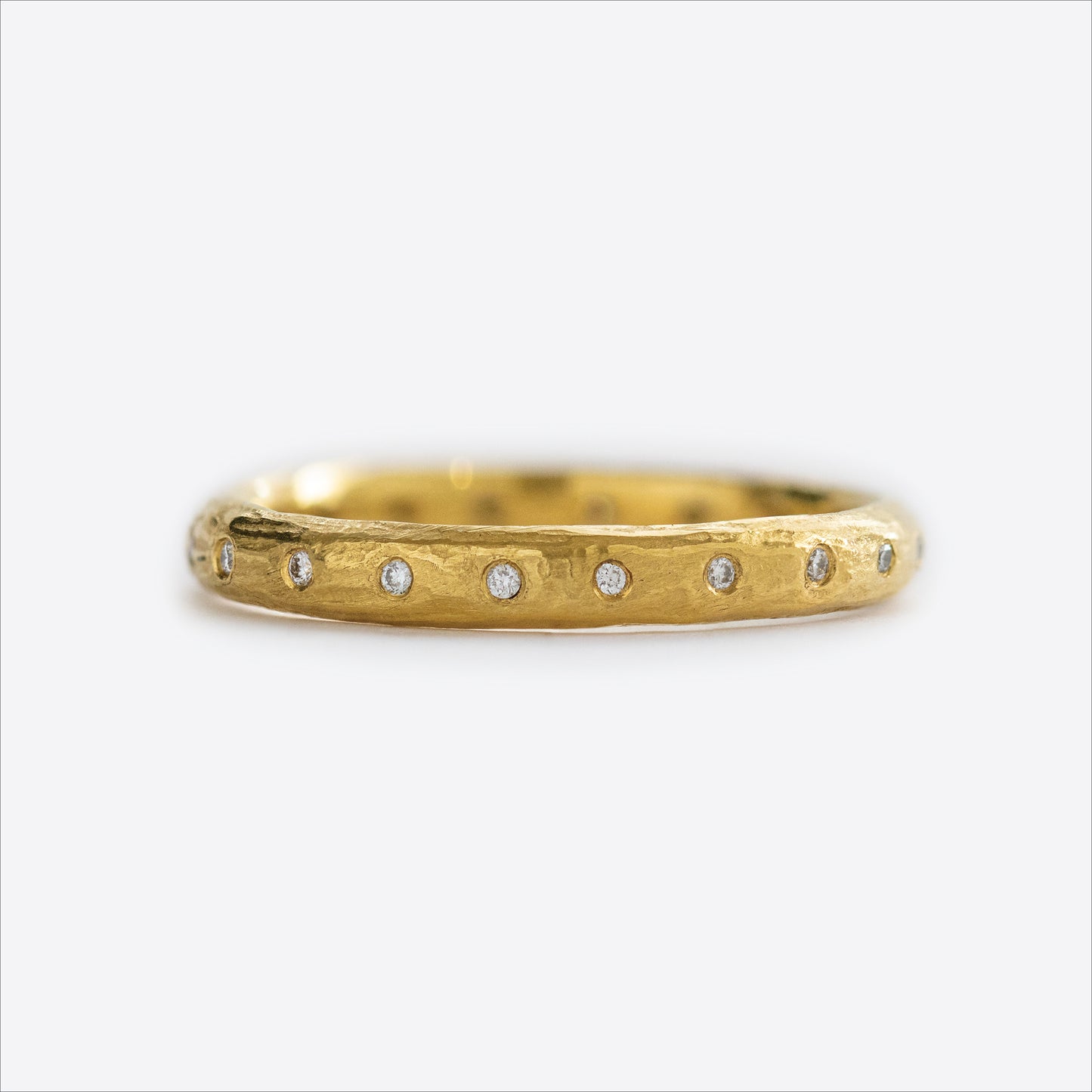 Close-up of a 22k yellow gold band with natural diamonds.
