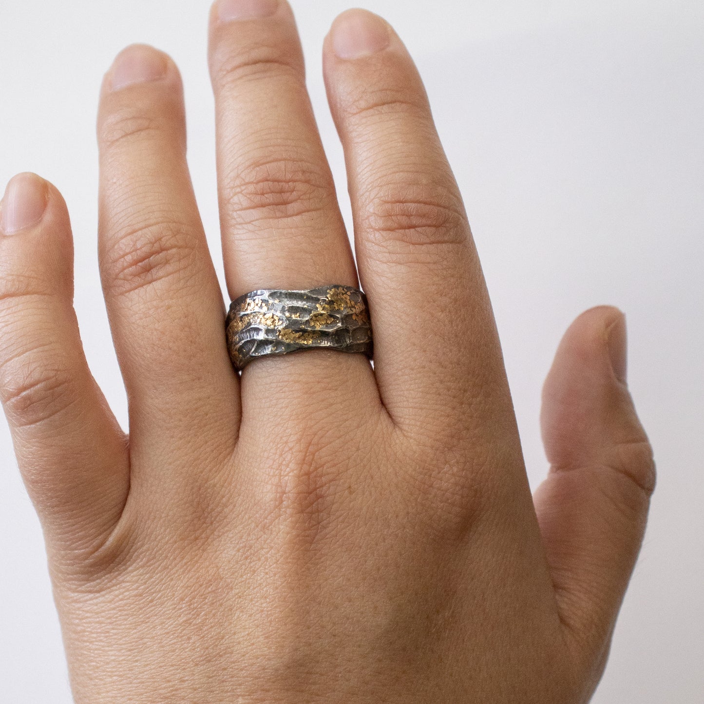 Oxidized and yellow metal redwood bark "burl" texture band on a hand