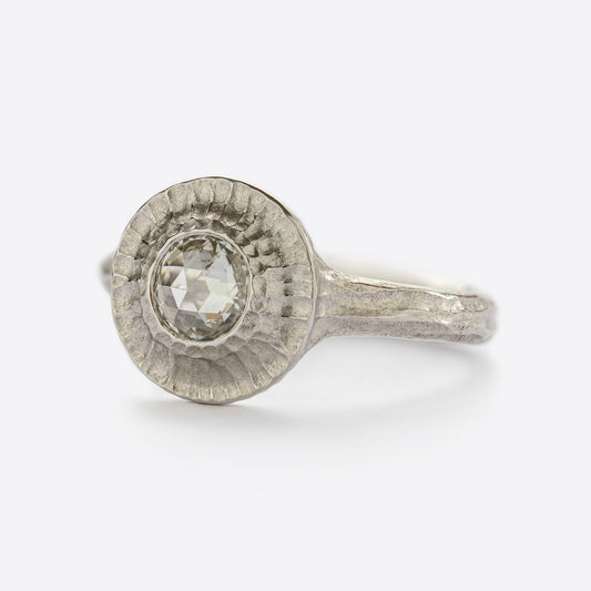 Side view of white metal ring with round gem