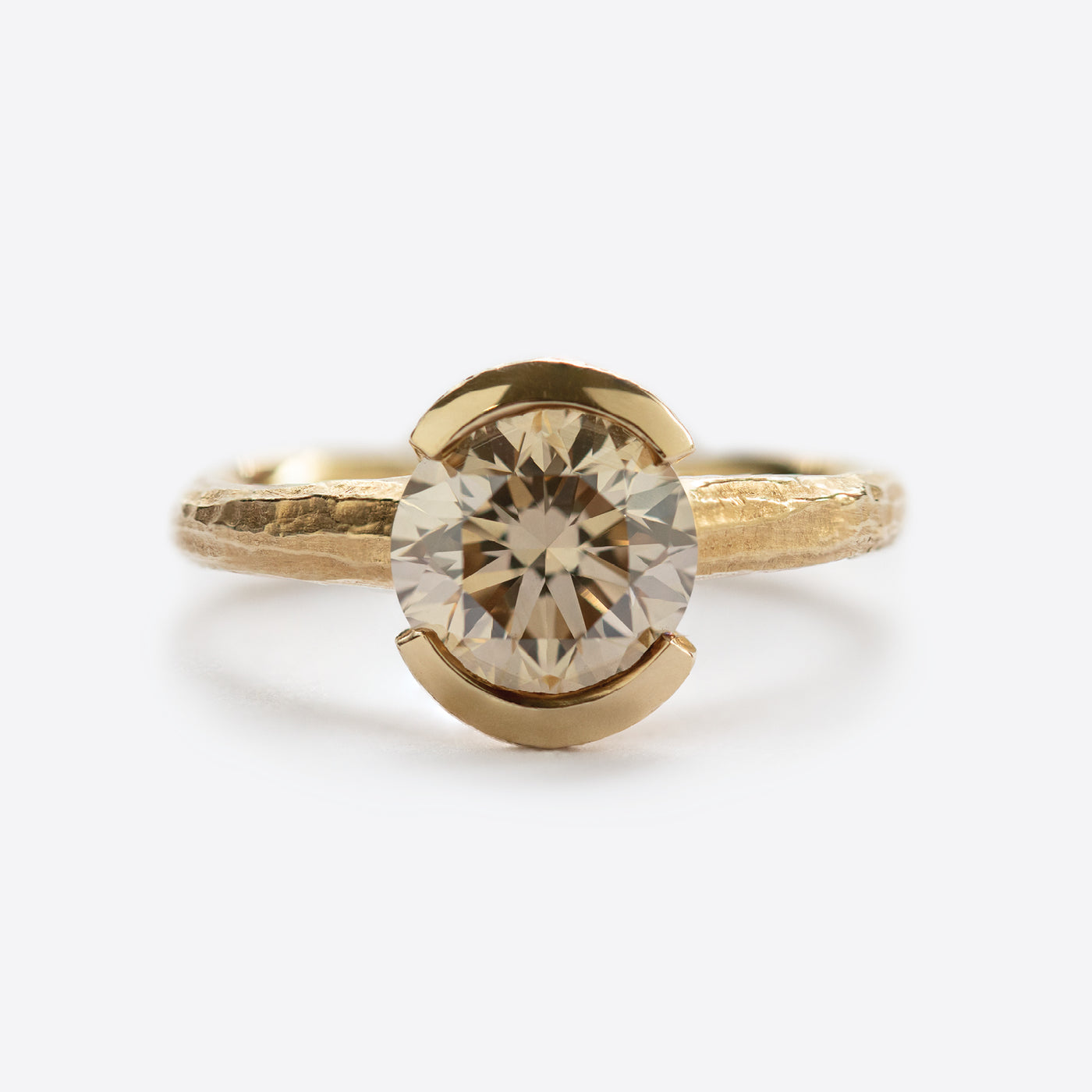 Yellow metal ring with round gem