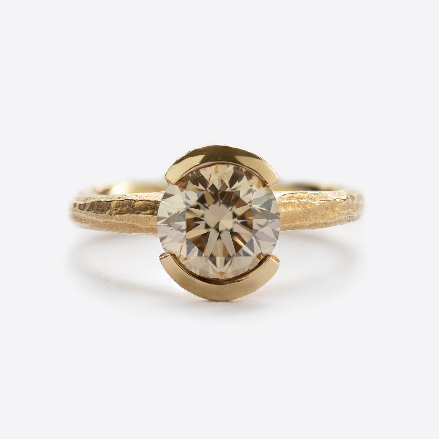 Yellow metal ring with round gem
